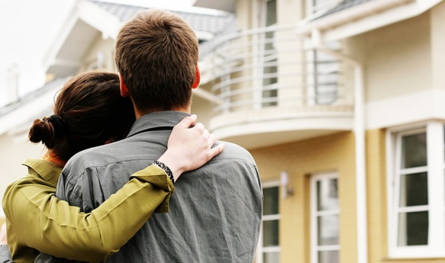 woman hugs her husband as they look at their new apartment